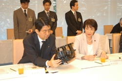 Prime Minister Shinzo Abe and Minister of State for Science and Technology Policy Sanae Takaichi get a feel of a cutting-edge plastic processed product
