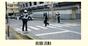 街頭活動。横断歩道を渡る人と横断歩道の両側に立つ警察官の写真