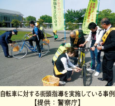 自転車に対する街頭指導を実施している事例【提供：警察庁】。警察官らが自転車の運転者に対して指導している様子の写真