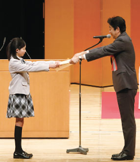 小学生の部 最優秀作 受賞者。内閣総理大臣から表彰状を受け取る龍道さんの写真