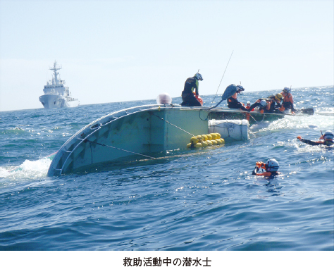 救助活動中の潜水士。転覆したボートで救助活動を行う潜水士の写真