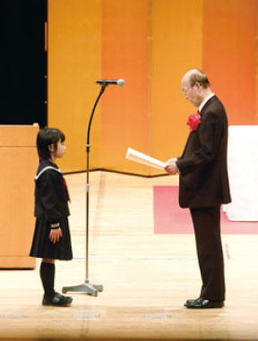 小学生の部 最優秀作 受賞者。表彰状を受け取る八幡さんの写真