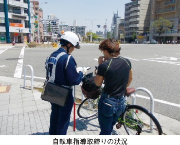 自転車指導取締りの状況。自転車から降りている人が警察官の聴取に応じている